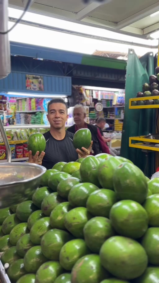 Comerciante mostrando aguacates